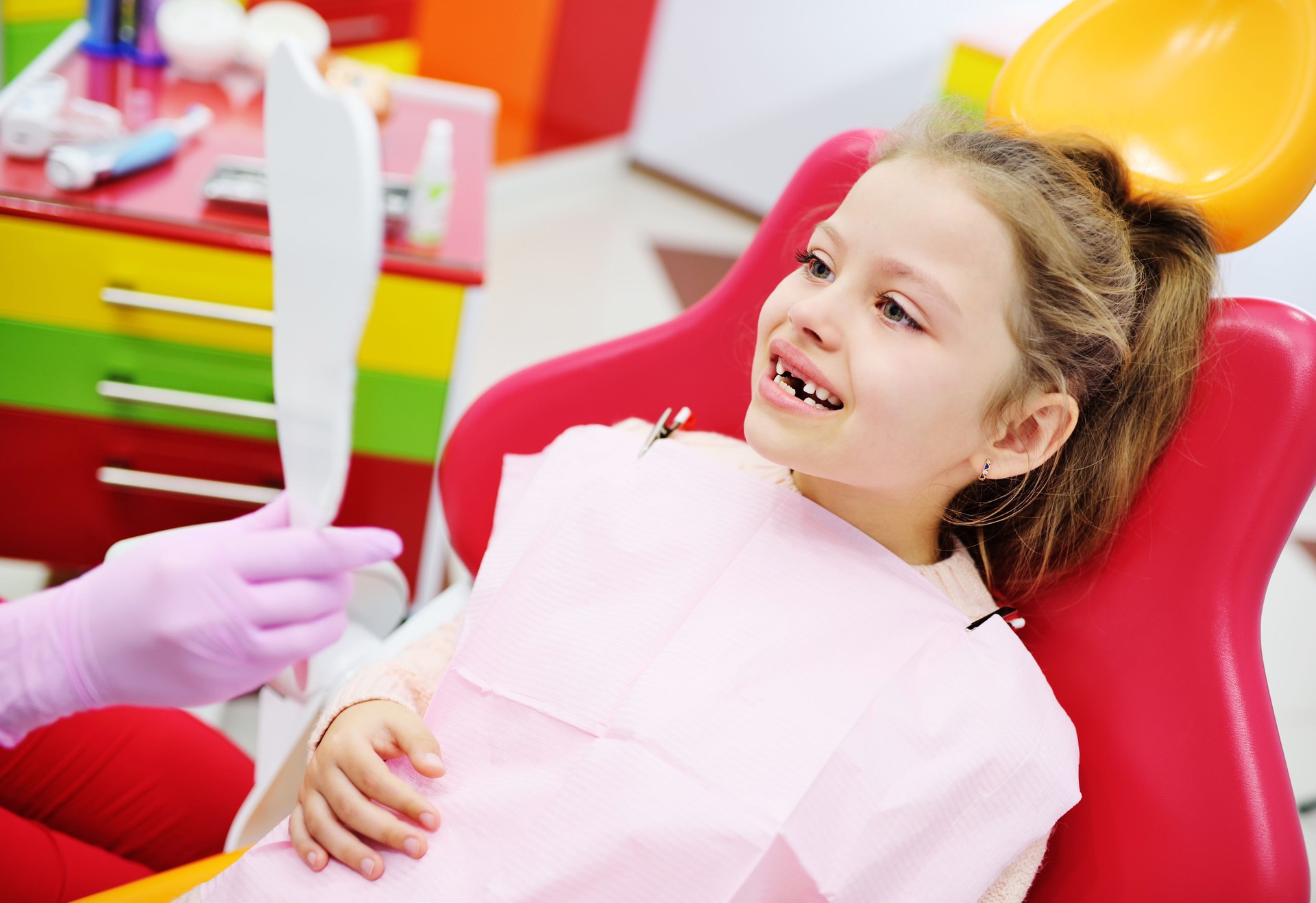 niño niña niño en edad preescolar con ninguna leche dientes sonriendo sentado en la silla dental.